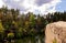 Young Handsome man in Hat On A Rock Admiring The View Of A Lake In Autumn.