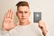 Young handsome man holding Australia Australian passport over isolated white background with open hand doing stop sign with