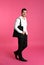 Young handsome man holding black tote bag on pink background, space for