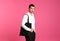 Young handsome man holding black tote bag on pink background, space for