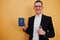 Young handsome man holding  Republic of Belarus passport id over yellow background, happy and show thumb up. Travel to Europe