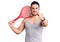 Young handsome man holding tennis racket annoyed and frustrated shouting with anger, yelling crazy with anger and hand raised