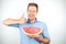 Young handsome man with red eyeglasses on his head holding ripe watermelon showing like sign on isolated white