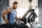 Young handsome man running on treadmill at gym