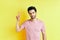 Young handsome man show victory sign on yellow background