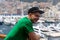 Young handsome man smiling on the ship with blurred sailboats and ships on background. Monte Carlo, Monaco