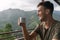 Young handsome man tasting a teacup over the jungle in sri lanka