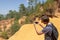 Young handsome man travel in mountains, caucasian male traveler outdoors at Ochre Trail in Roussillon, France