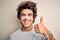 Young handsome man using nose strip standing over isolated white background doing happy thumbs up gesture with hand