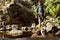 Young handsome man walking with huskies dog in canyon near water.