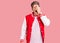 Young handsome man wearing baseball uniform yawning tired covering half face, eye and mouth with hand