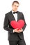 Young handsome man wearing black suit and holding a red heart