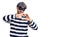 Young handsome man wearing burglar mask smiling in love doing heart symbol shape with hands