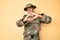 Young handsome man wearing camouflage army uniform smiling in love doing heart symbol shape with hands