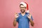 Young handsome man wearing christmas hat over isolated pink background smiling positive doing ok sign with hand and fingers.