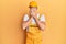 Young handsome man wearing handyman uniform over yellow background rubbing eyes for fatigue and headache, sleepy and tired
