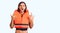 Young handsome man wearing nautical lifejacket shouting with crazy expression doing rock symbol with hands up