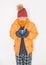 Young handsome man wearing in red hat and yellow down jacket feeling cold hold cup of hot drink. Gas crisis concept