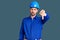 Young handsome man wearing worker uniform and hardhat afraid and terrified with fear expression stop gesture with hands, shouting