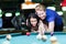 Young handsome man and woman flirting while playing snooker