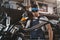 young handsome mechanic in goggles with circular saw in workshop