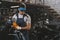 young handsome mechanic in goggles with circular saw in workshop