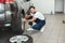 Young handsome mechanic wearing uniform working in car service department fixing flat tire looks happy