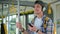 Young handsome men enjoying trip in the public transport, standing with headphone while moving in the modern tram