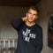 Young handsome model man in black pullover with text in studio.