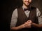 Young handsome old-fashioned man with beard posing on dark background.