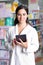 Young handsome pharmacist with a tablet in a drug store