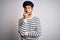 Young handsome sailor man with beard wearing navy striped uniform and captain hat with hand on chin thinking about question,