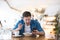 Young handsome smiling man drinks his hot coffee and eats salad for lunch while reading message in his smartphone during break at