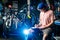 Young handsome stylish man in a cap and with a tattoo small business owner selling a bicycle, the workshop sits on the background