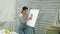A young handsome teacher draws on a blackboard, teaches in art class