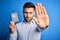 Young handsome tourist man holding australia australian passport id over blue background with open hand doing stop sign with