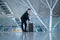 Young handsome traveling man in a suit next to his rolling suitcase