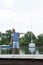 Young handsome yachtsman in sun glasses walking at river pier and welcomes friends. Handsome businessman invites to his boat.