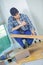 Young handyman fitting wooden floor at construction site