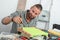 Young handyman painting a small piece of furniture in green