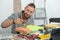 Young handyman painting a small piece of furniture in green