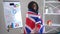 Young happy African American woman wrapping in British flag looking at camera smiling. Portrait of smart successful