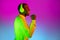 Young happy African handsome man with headphones isolated over gradient magenta yellow neon background.