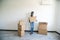 Young happy afro american woman carrying cardboard boxes after relocation in her new appartment