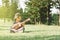 Young and happy asian girl playing with ukelele guitar at the park in sunny morning