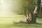 Young and happy asian girl playing with ukelele guitar at the park in sunny morning