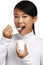 Young happy asian woman eating fresh yogurt