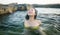 Young happy and attractive Asian woman in the sea - cheerful and carefree Japanese girl playful in the water during Summer