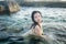 Young happy and attractive Asian woman in the sea - cheerful and carefree Korean girl playful in the water during Summer holidays
