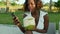 Young happy and attractive black afro American woman using internet social media on mobile phone at tropical beach resort chilling